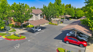 exterior aerial, parking lot, covered and non covered parking available, meticulous landscaping, lush foliage, parking in front of residential buildings