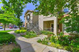 Exterior residential building, two story walk-up, meticulous landscaping, flowers in bloom.